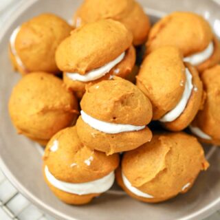 You'll love this sandwich cookie recipe for Pumpkin Whoopie Pies that brings a warm yummy flavor of fall. It is easy to make by combining pumpkin puree, flour, oil, egg, brown sugar, and some fall spices. Whip together a simple cream cheese and powdered sugar frosting for the filling for a treat everyone will want to try!
